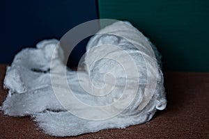 Unwound roll of white cotton on the table