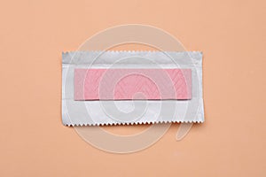 Unwrapped stick of chewing gum on coral background, top view