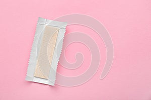 Unwrapped stick of chewing gum on pink background, top view. Space for text