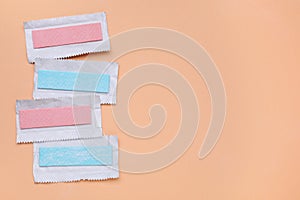 Unwrapped sticks of chewing gum on coral background, flat lay. Space for text