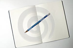 Unwritten notebook with blue pencil on it