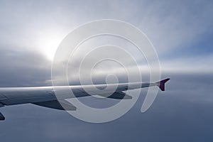 Up in the air, view of aircraft wing silhouette with dark blue sky horizon