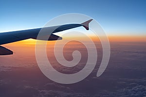 Up in the air, view of aircraft wing silhouette with dark blue sky horizon