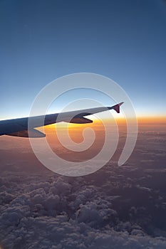 Up in the air, view of aircraft wing silhouette with dark blue sky horizon