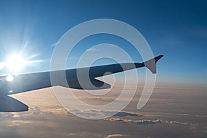 Up in the air, view of aircraft wing silhouette with dark blue sky horizon