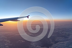 Up in the air, view of aircraft wing silhouette with dark blue sky horizon