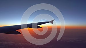 Up in the air, view of aircraft wing silhouette with dark blue sky horizon