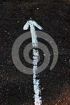 The up arrow on the asphalt is drawn in white paint