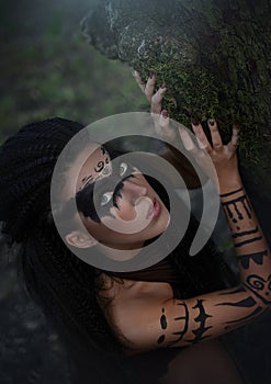 An up close portrait of a wild Amazon girl. Shaman girl with long black hair and ritual makeup