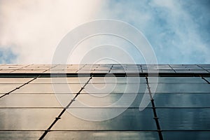 Up view on modern business office building and sky on the background. Urban exterior and tall perspective.