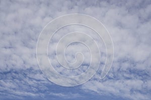 Up ward view, wave of softy and white fluffy clouds under deep blue sky