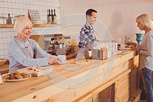 Upbeat baristas serving coffee and croissants for customers