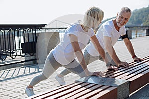 Upbeat couple doing stretching exercises together