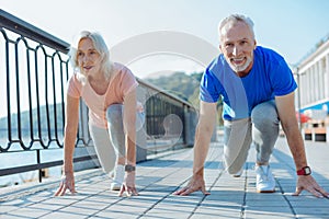 Upbeat elderly couple being about to start race
