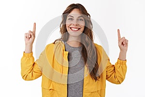 Upbeat energized good-looking curly european girl pointing hands up showing cool new promo smiling toothy happily