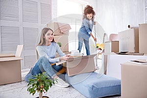 Upbeat female students unpacking and cleaning dorm room