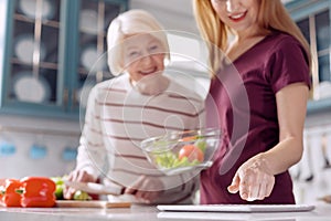 Upbeat women checking salad recipe on tablet