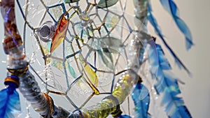 An upclose look at a dreamcatcher made from up plastic bottles showing the intricate and delicate nature of the art form