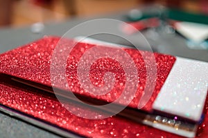 Upclose photo of a pile of colorful rectangular paper tiles covered with sparkling glitter