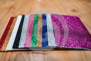 Upclose shallow depth of field shot of a pile of colorful rectangular paper tiles covered with sparkling glitter