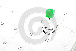 Upcoming Events written on a calendar with a green push pin to r photo