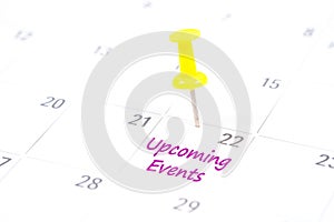 Upcoming Events written on a calendar with a yellow push pin to