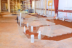 Upcoming lavatory restroom concrete floor displays exposed drainage pvc pipe endings for plumbing