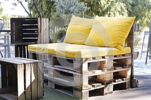 Upcycled outdoor seat made from pallets with wood crate as table photo