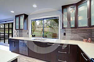 Updated contemporary kitchen room interior in white and dark tones.