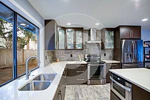 Updated contemporary kitchen room interior in white and dark tones. photo