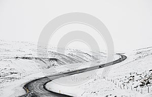 Uphill curve road with side way full of snow in winter