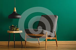 Upholstered chair by green wall