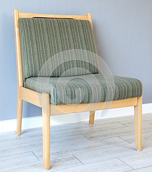 Upholstered furniture chair on a background of gray wall. Interior.