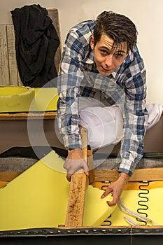 Upholsterer padding a sofa