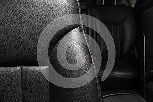 Upholstery of the seats of passenger compartment of a luxury car with black genuine leather in a workshop for hauling vehicles