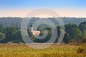 Upper Bavarian autumn landscape with small church in morning mist forest