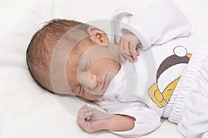 Upper body portrait of a newborn baby peacefully slept in bed