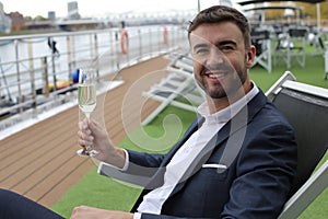 Upper class elegant man drinking champagne in private yacht