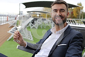 Upper class elegant man drinking champagne in private yacht