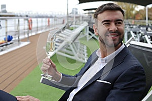 Upper class elegant man drinking champagne in private yacht