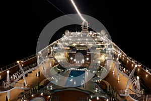 The upper deck of a giant cruise liner at night. View from above