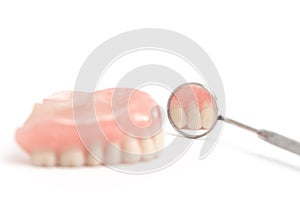 Upper dentures and dental mirror on white background,Selective f