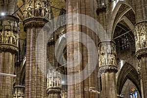 Center Nave columns inside interior Duomo di Milano. with statues serving crowns.