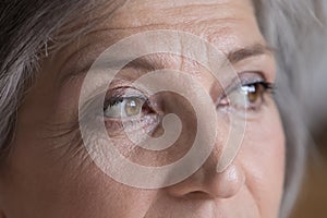 Upper face of serious senior woman looking away photo