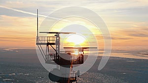 Upper ground of communication tower illuminated by sunset