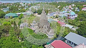 Upper panorama coral Buddhist temple in city against sea