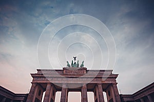 Upper part of brandenburg gate in berlin on a colorful evening with picturesque clouds. Colossal monument in berlin