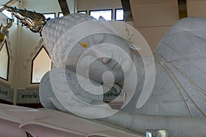 Upper part on gigantic white reclining Buddha made of white marble In Buddha image hall at Wat Pha Phu Gon temple