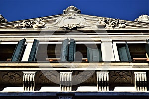 Upper part, outlined by the blue sky and illuminated by the sun of a winter afternoon, of a historic building in Padua.