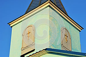 The upper part of the roof of the Orthodox Church with small arched doors against a blue sky